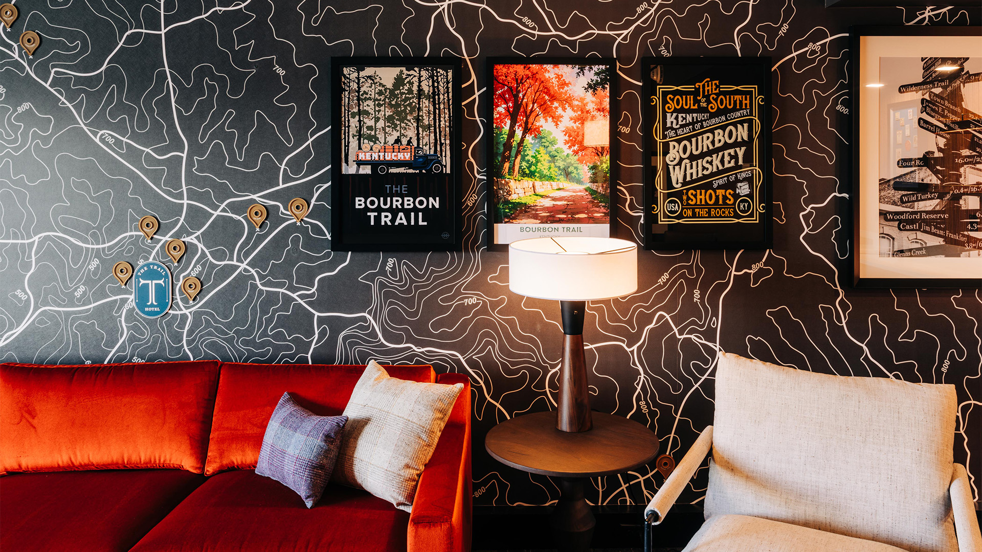 a room with a lamp and posters on the wall