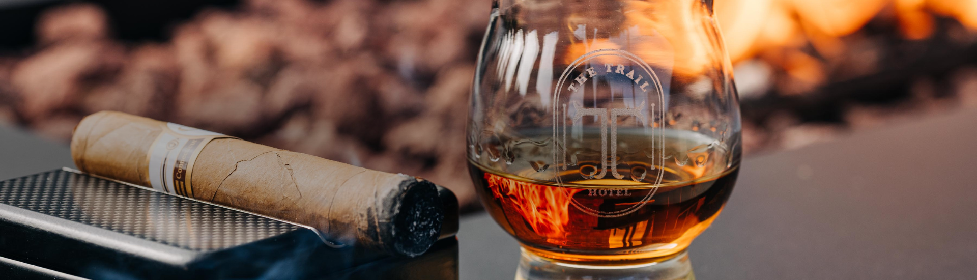 a glass of alcohol next to a cigar