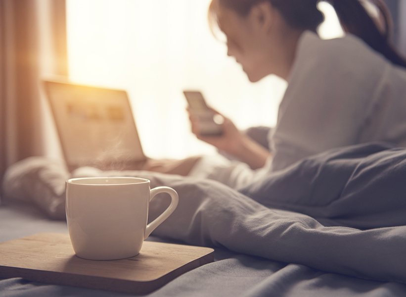 a cup of coffee and a woman in bed