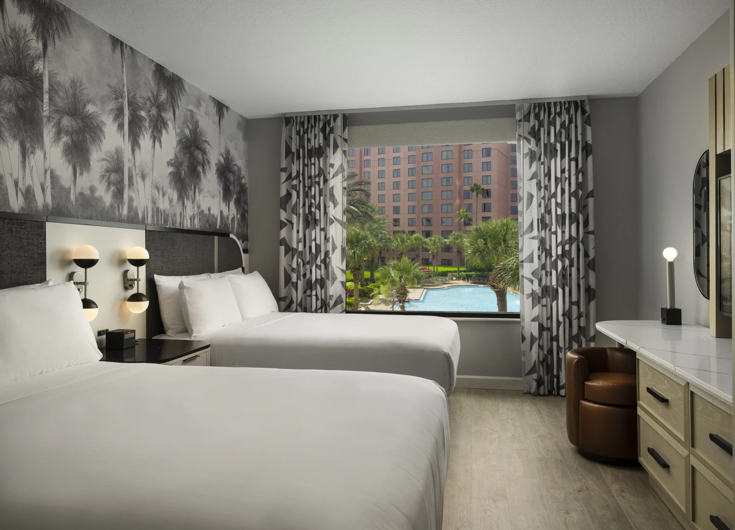 a room with two beds and a pool in the background
