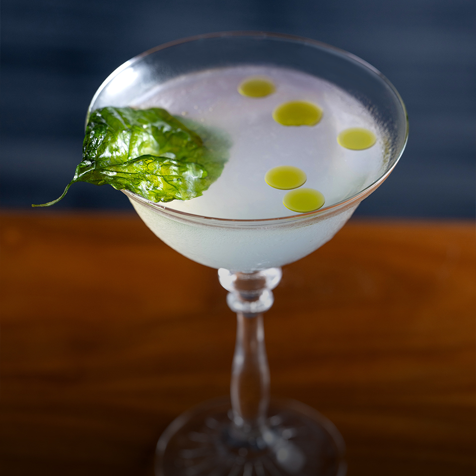 a glass with a drink and a leaf on it
