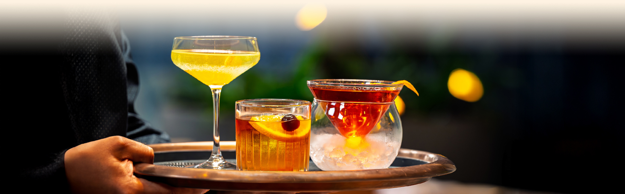 a group of glasses with different colored drinks on a tray