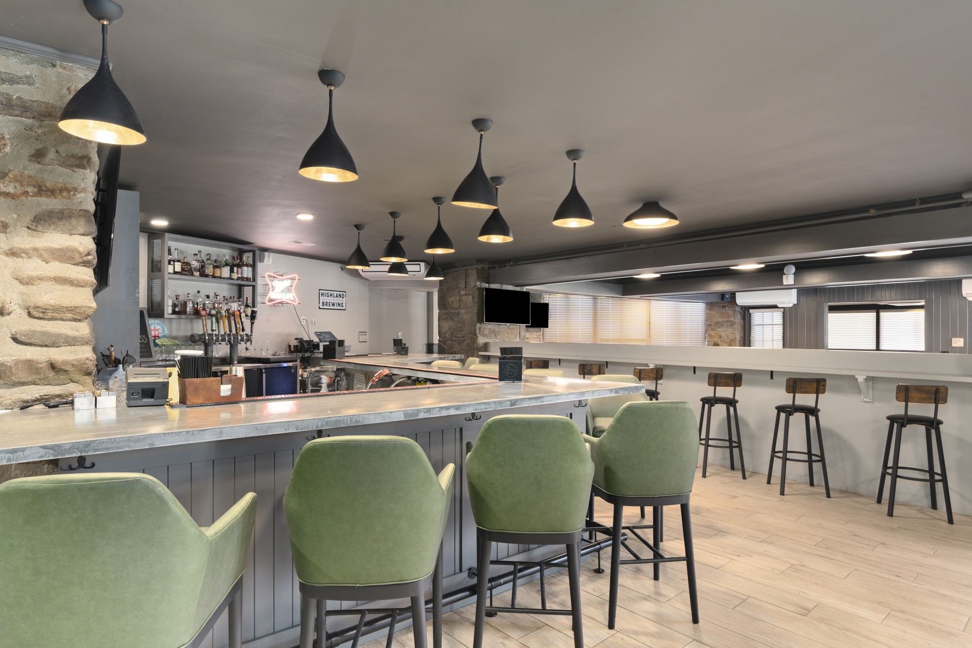 a bar with green chairs and a counter