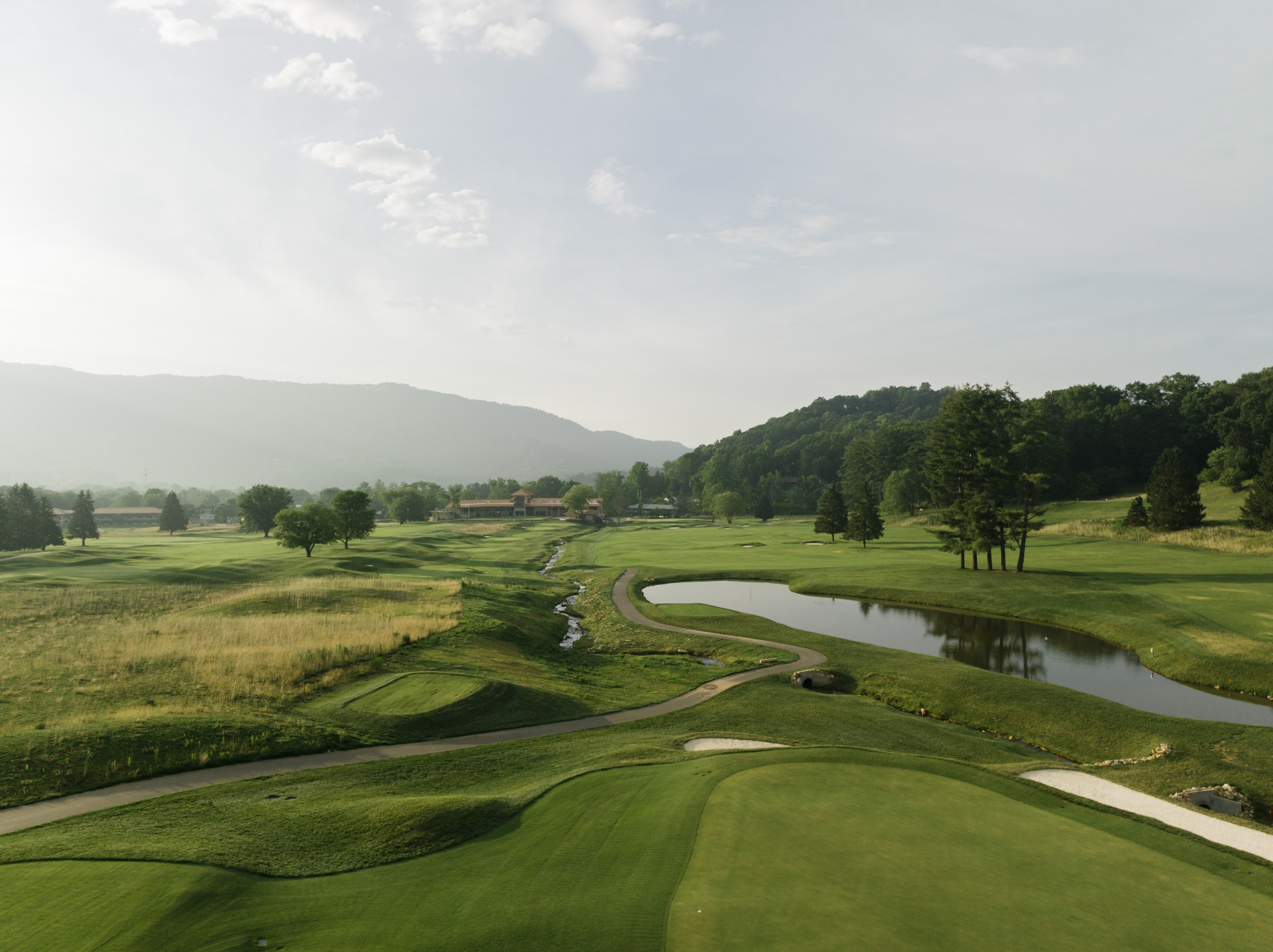a golf course with a lake and trees