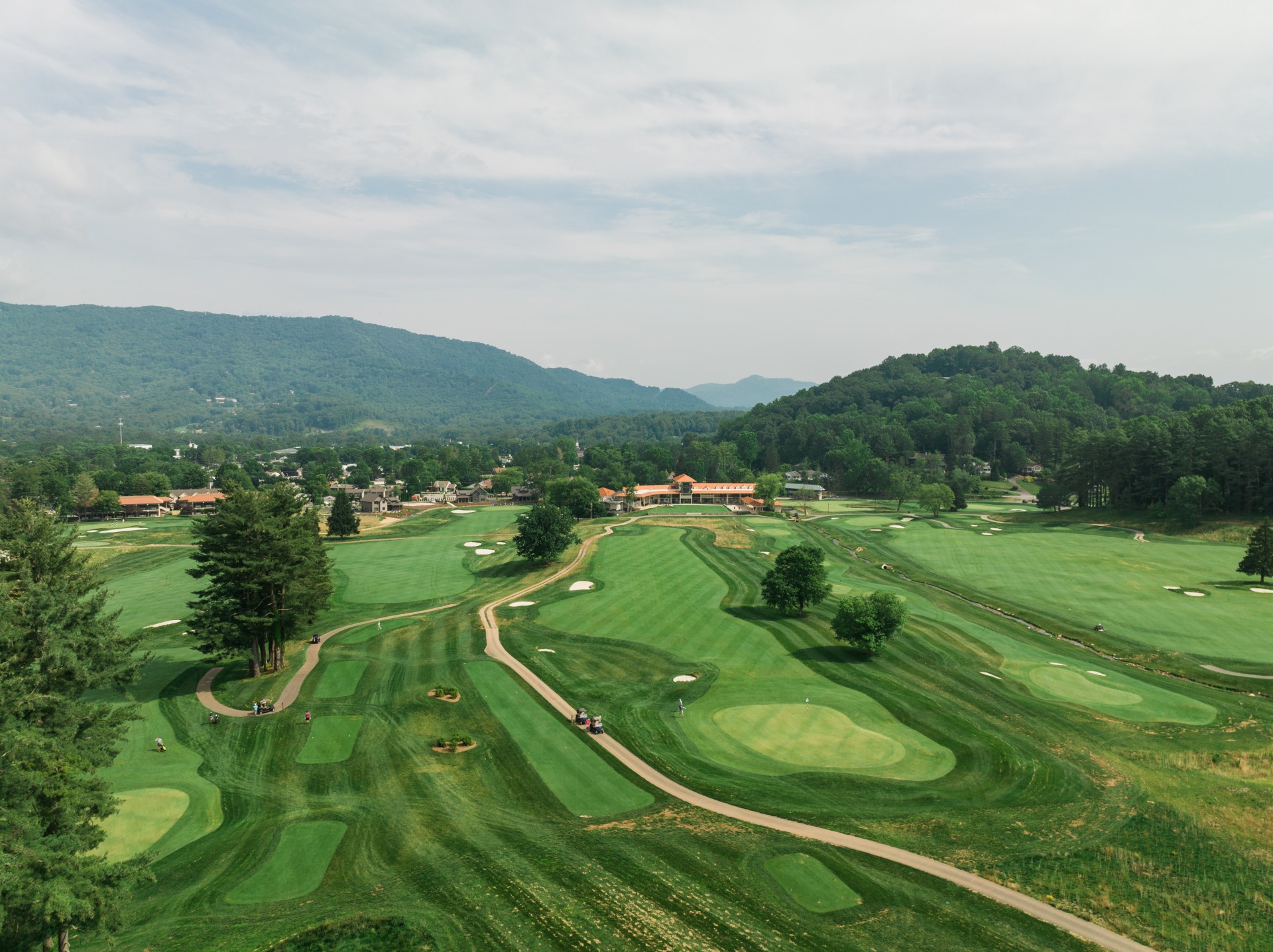 a golf course with trees and a building
