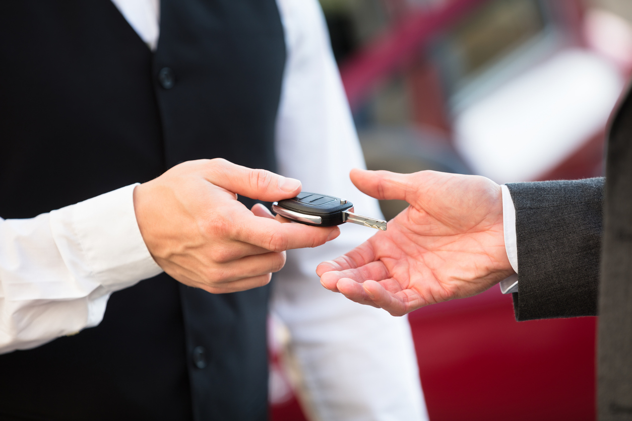 a person handing a car key to another person