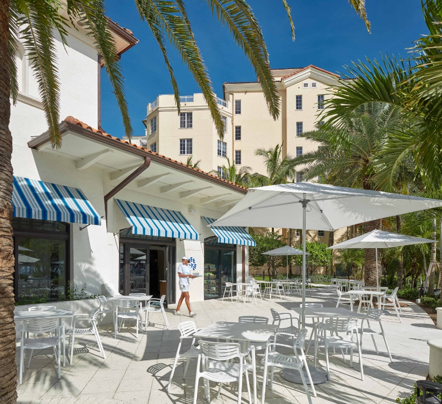 a white tables and umbrellas outside of a building