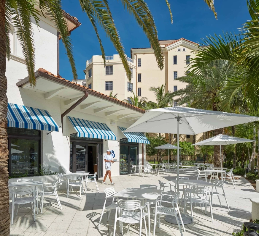 a white tables and umbrellas outside of a building