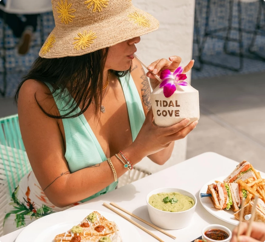 a woman drinking from a coconut cup