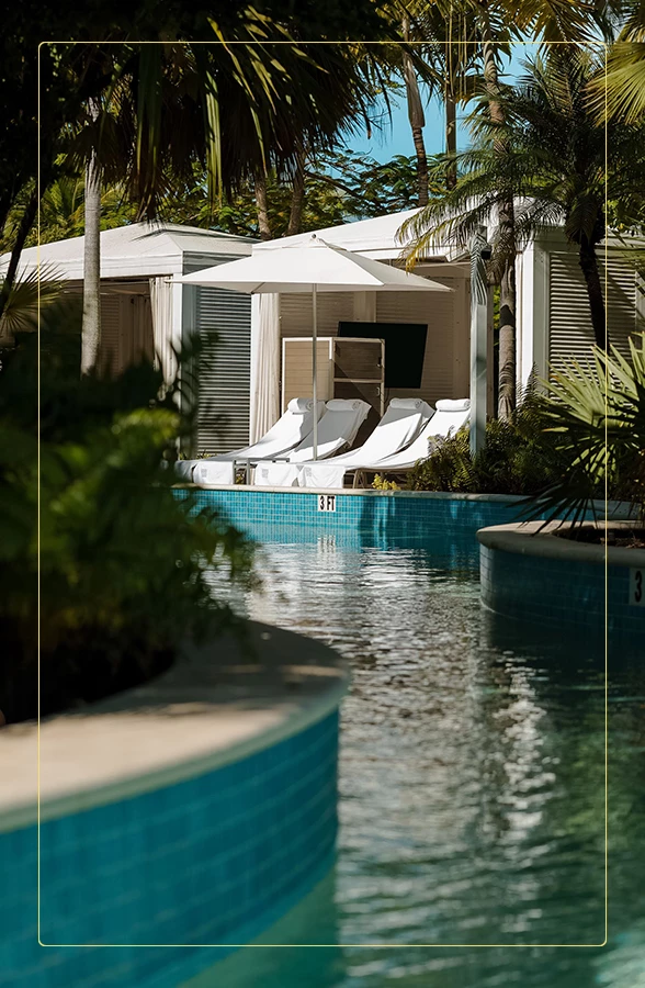 a pool with lounge chairs and umbrellas