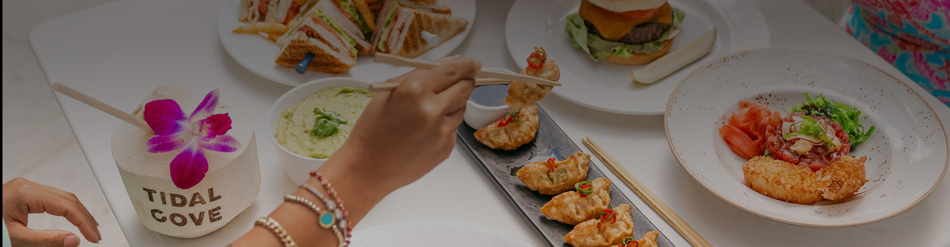a person holding chopsticks over food
