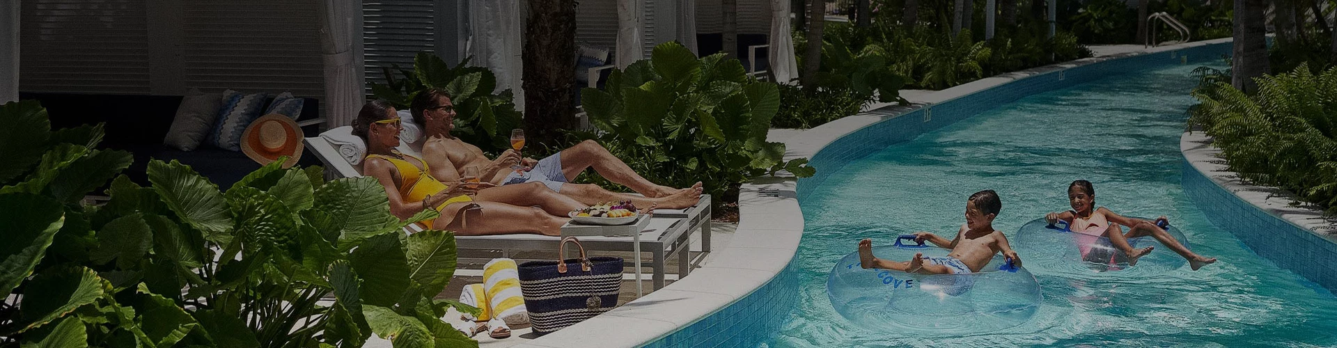 a man and woman lying on a lounge chair by a pool