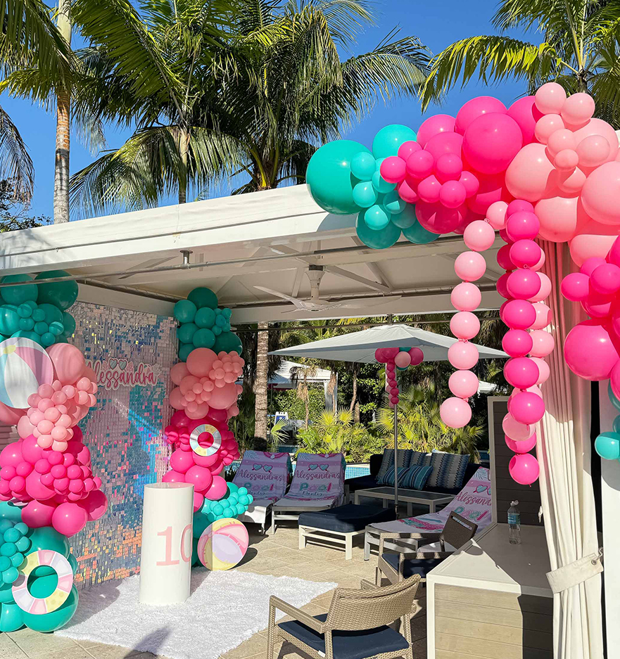 a balloon decorations outside with chairs and umbrellas