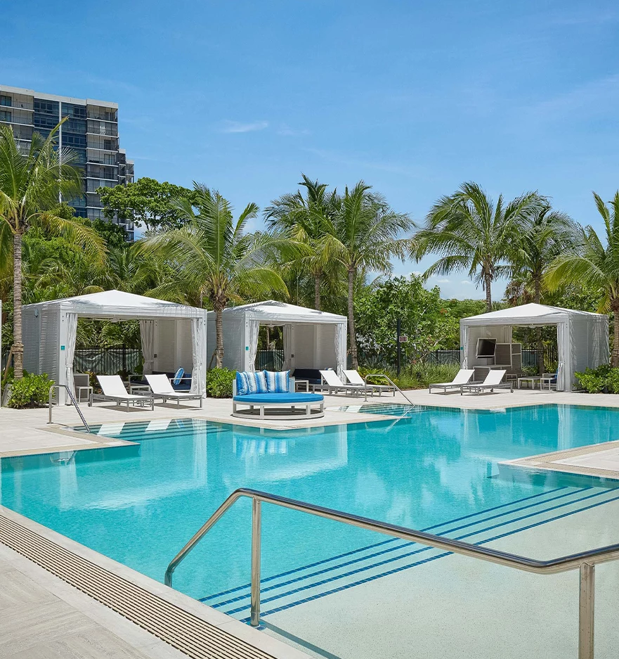 a pool with lounge chairs and a metal railing
