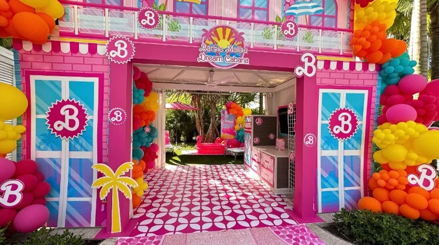 a pink and blue building with balloons