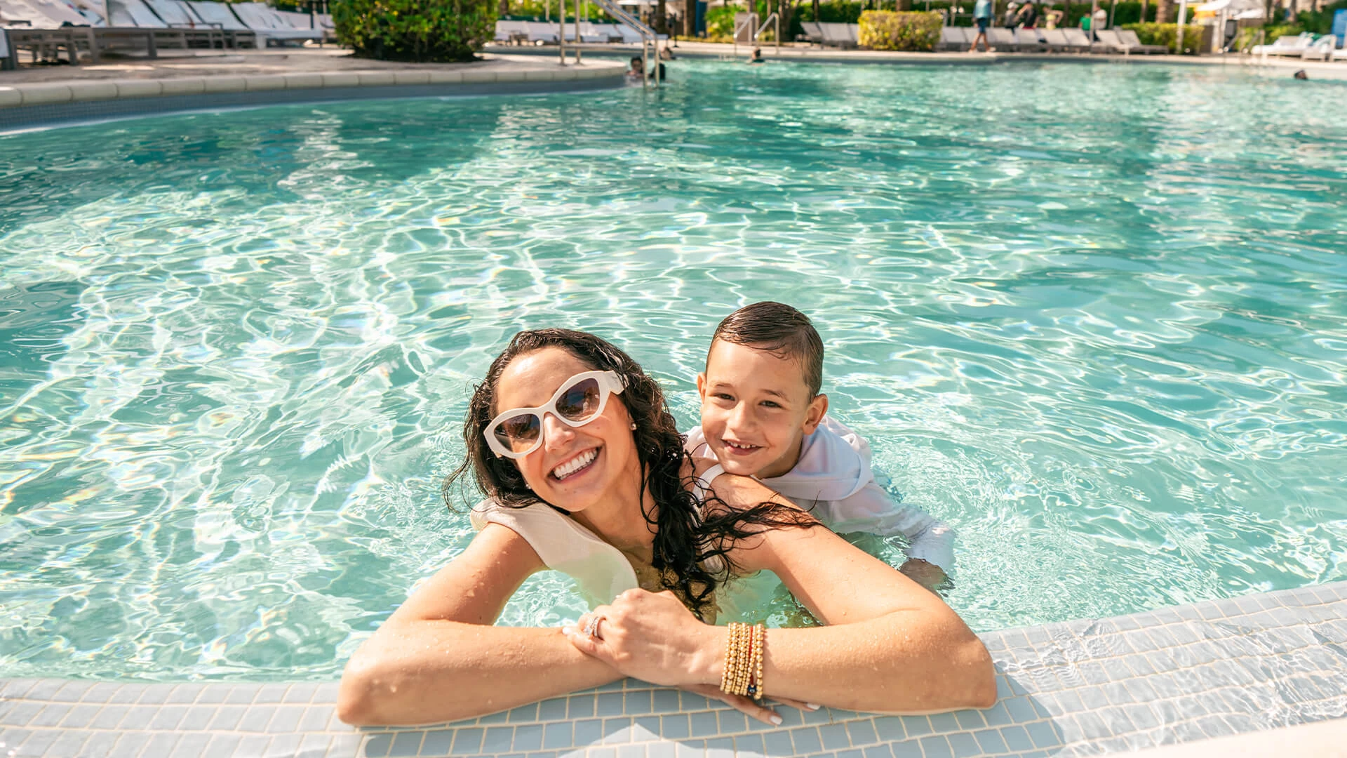 a woman and boy in a pool