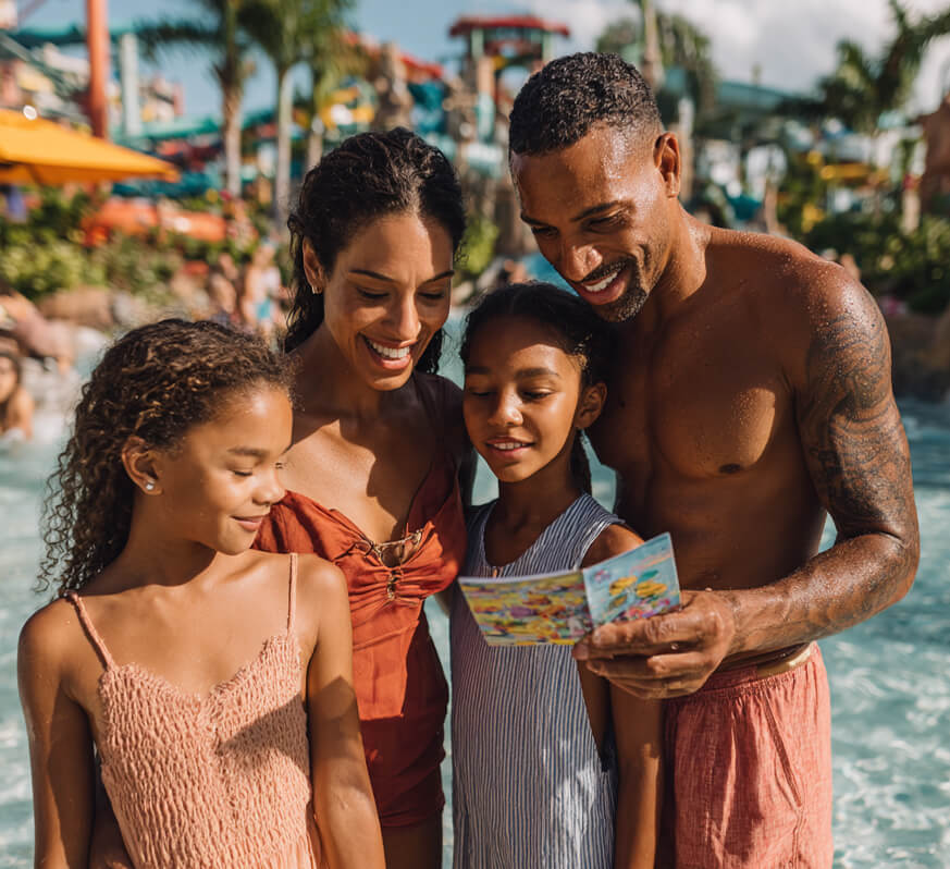 a man and woman with two girls looking at a map