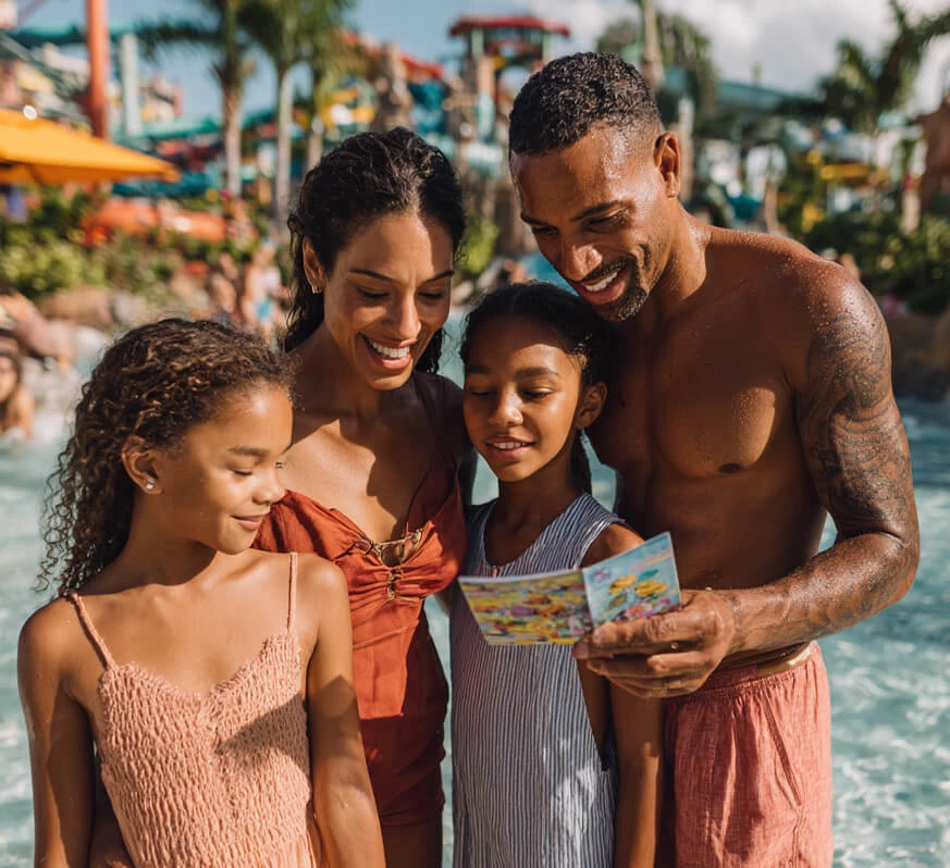 a man and woman with two girls looking at a map
