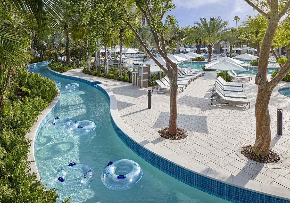 a pool with white chairs and trees