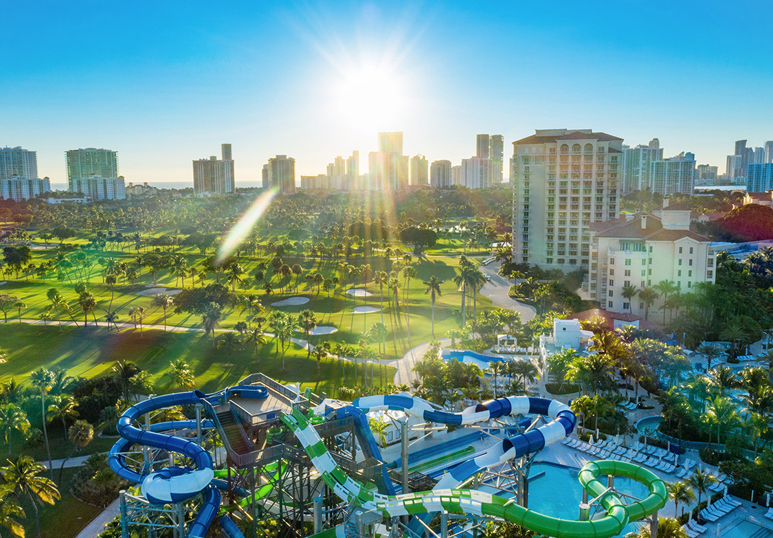 a water park with a water slide and a city in the background