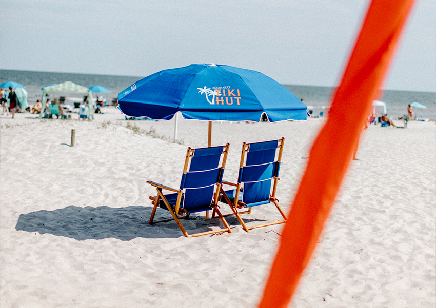 a blue beach chairs and umbrella on a beach