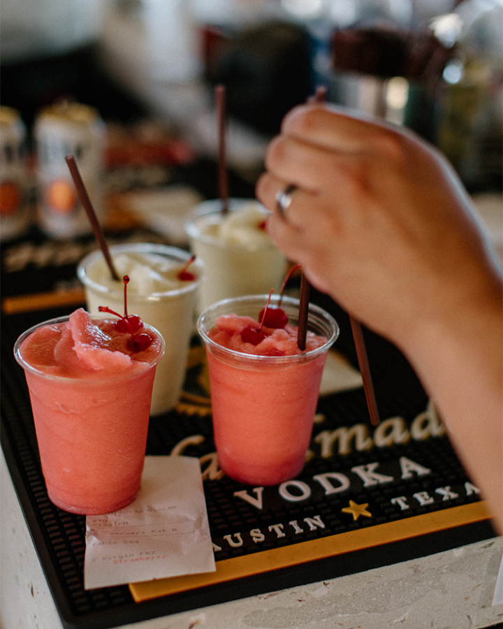 a person pouring a drink into cups