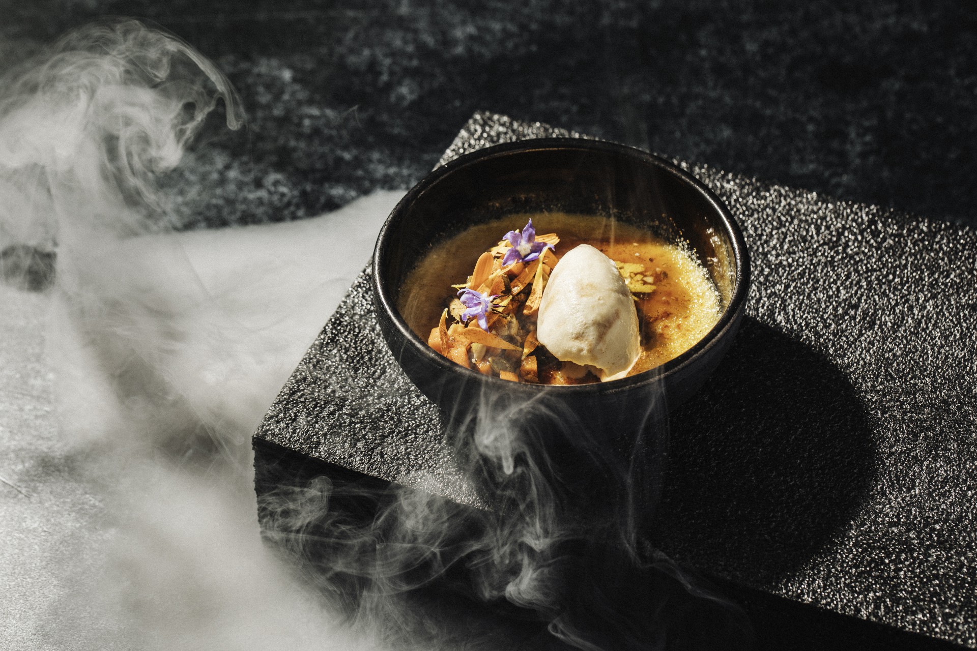a bowl of soup with ice cream and flowers
