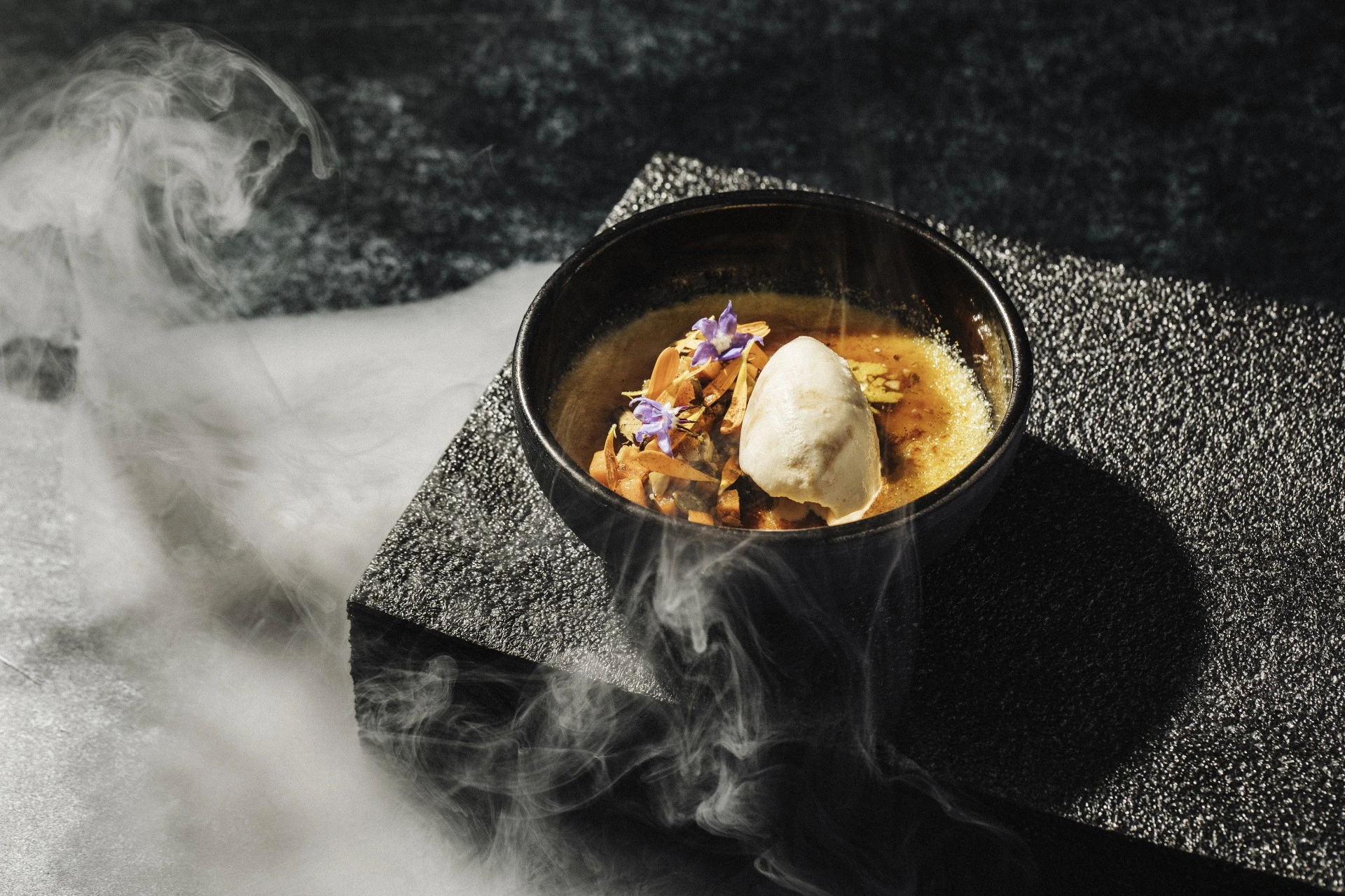 a bowl of soup with ice cream and flowers