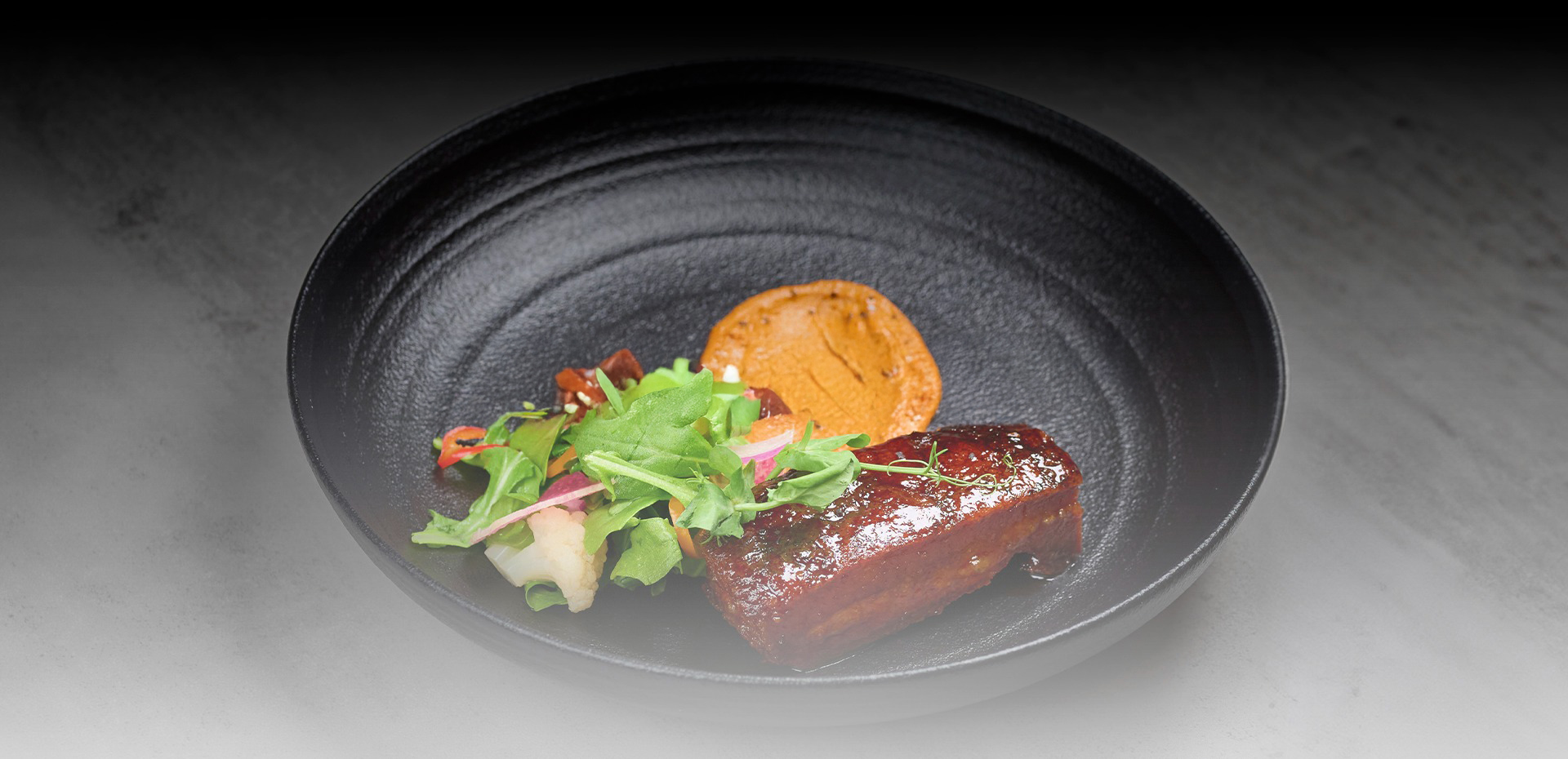 a plate of food on a black surface