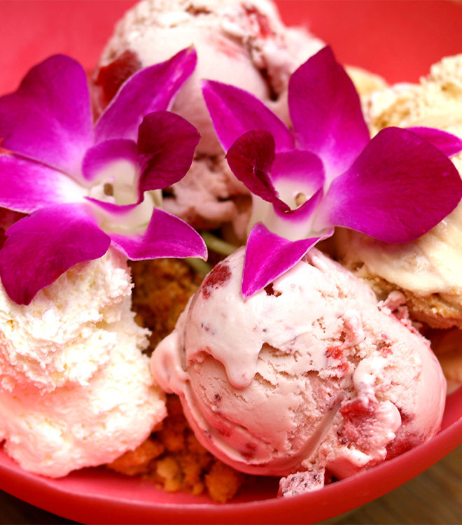 a bowl of ice cream with purple flowers