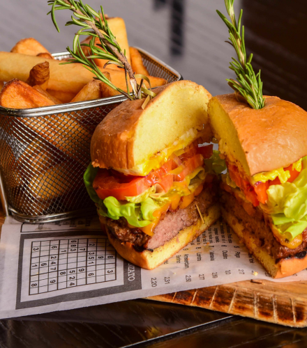 a burger cut in half with fries in a basket