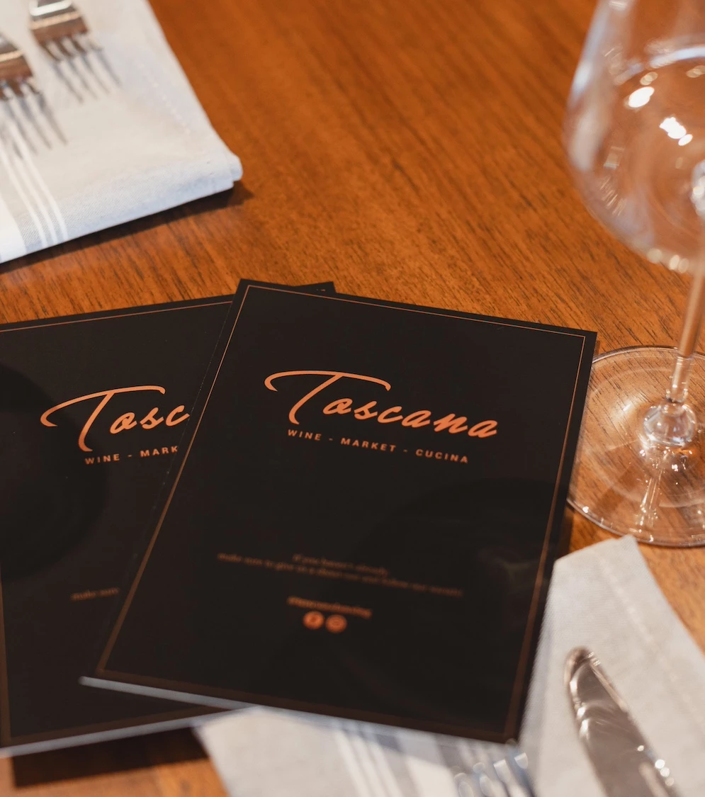 a table with a glass and napkins and a menu