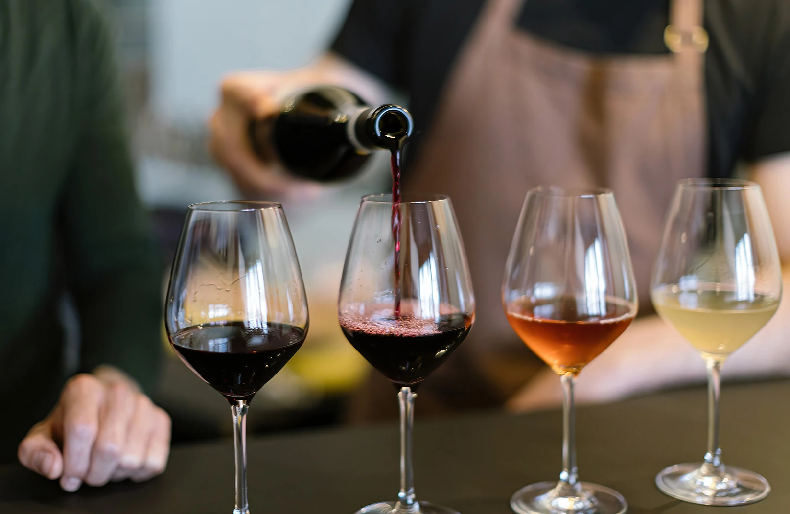 a woman pouring wine into glasses
