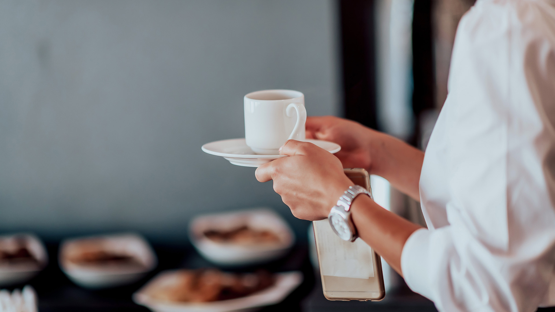 a person holding a cup and saucer