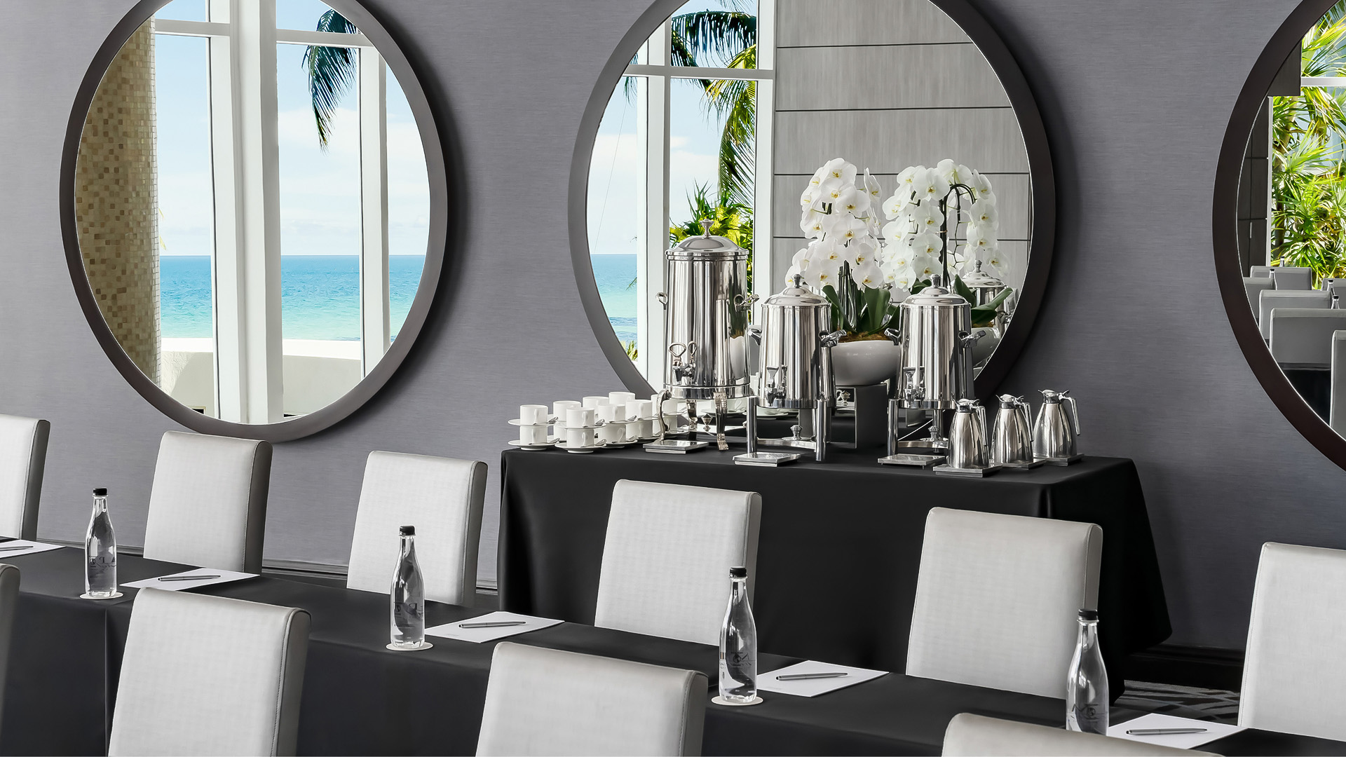 a table with a mirror and a table with white chairs and a black table