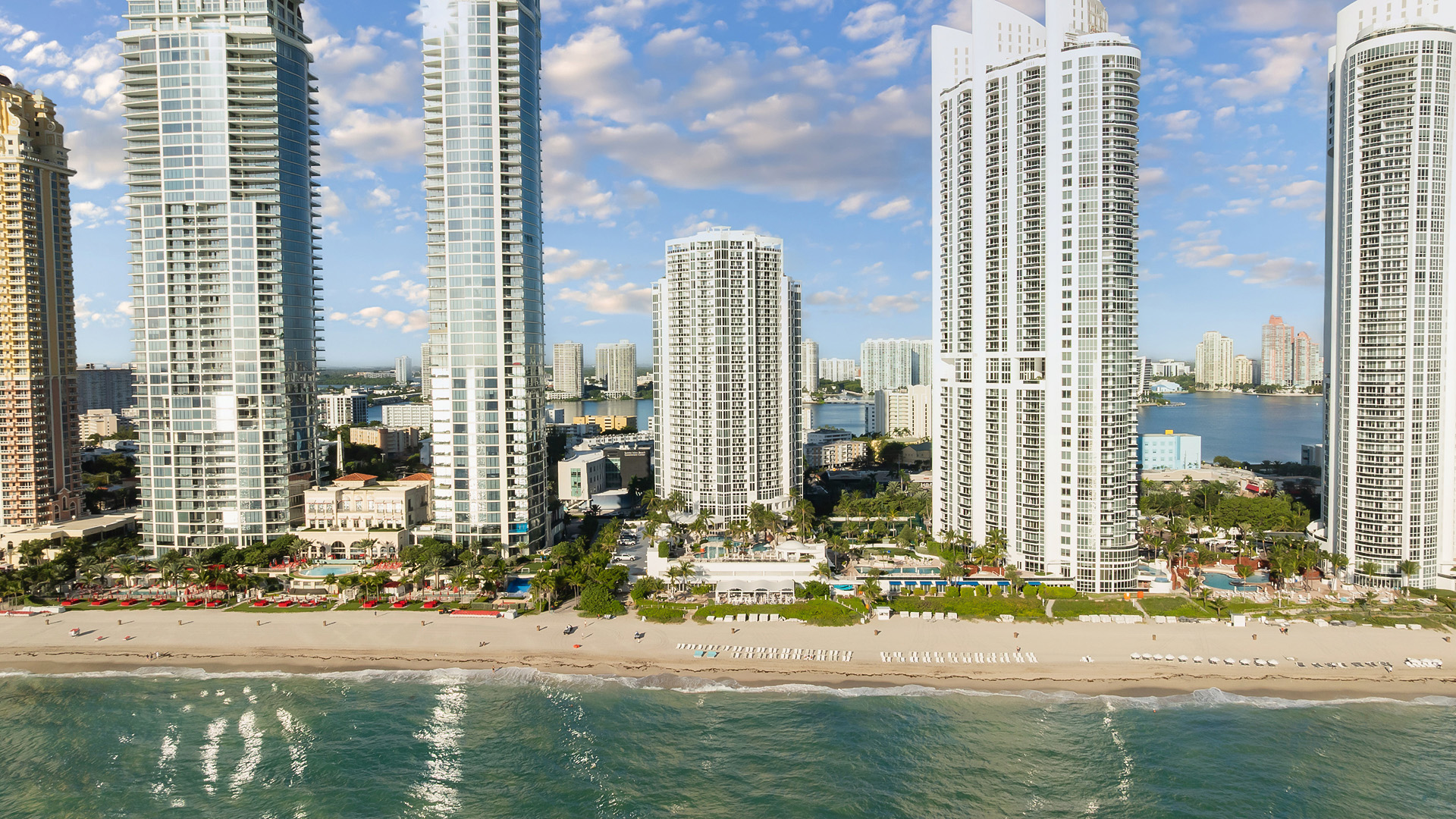 a beach with tall buildings and a body of water