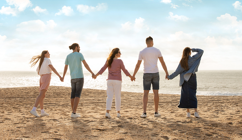 a group of people holding hands on a beach