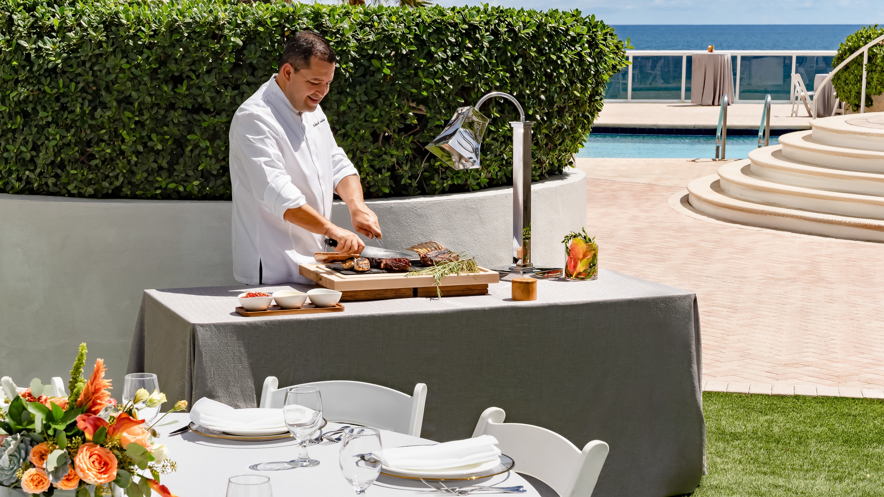 a man in a white coat cutting fish on a table