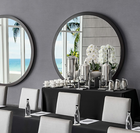 a table with a mirror and a vase of flowers