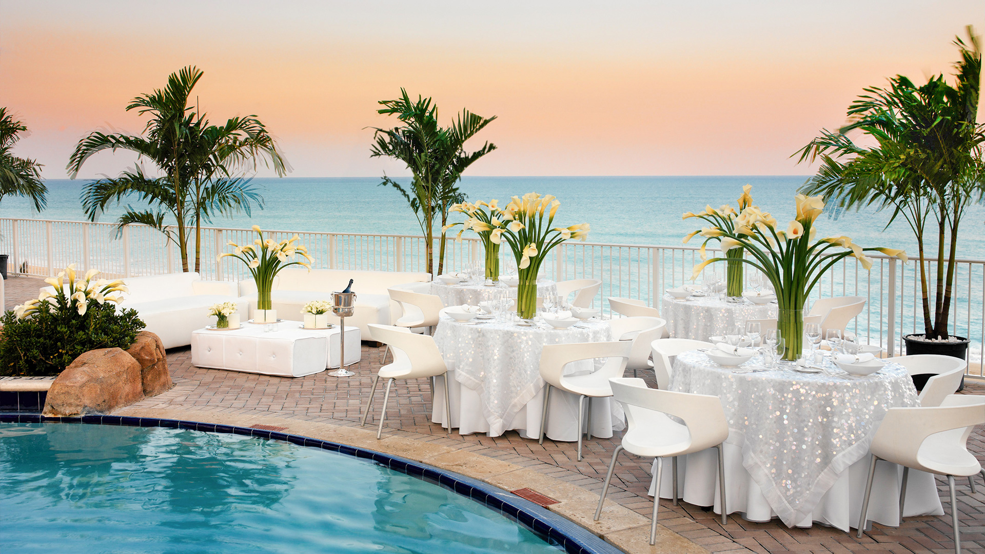 a pool with tables and chairs and flowers
