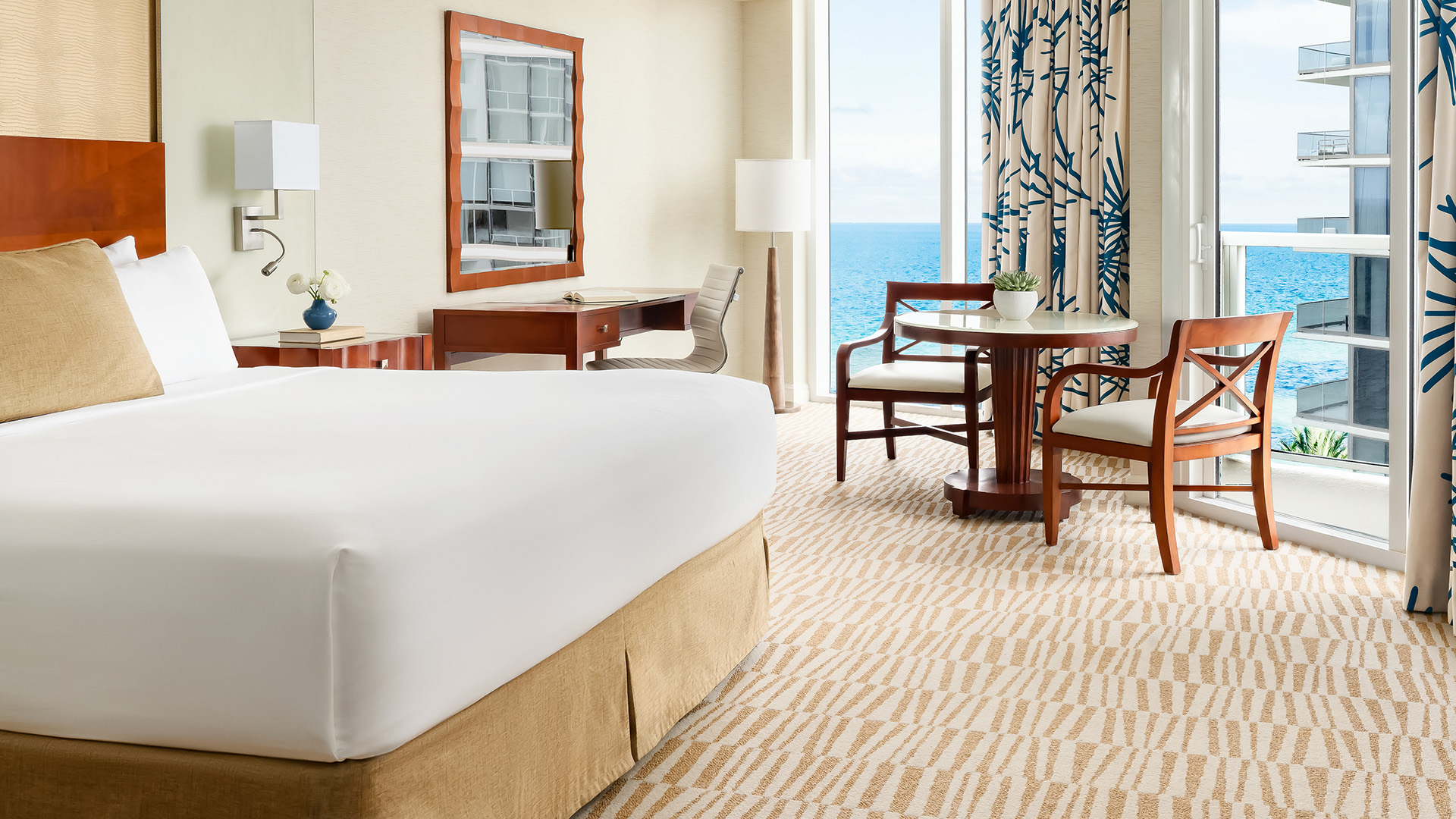 A modern hotel guest room with ocean view and balcony