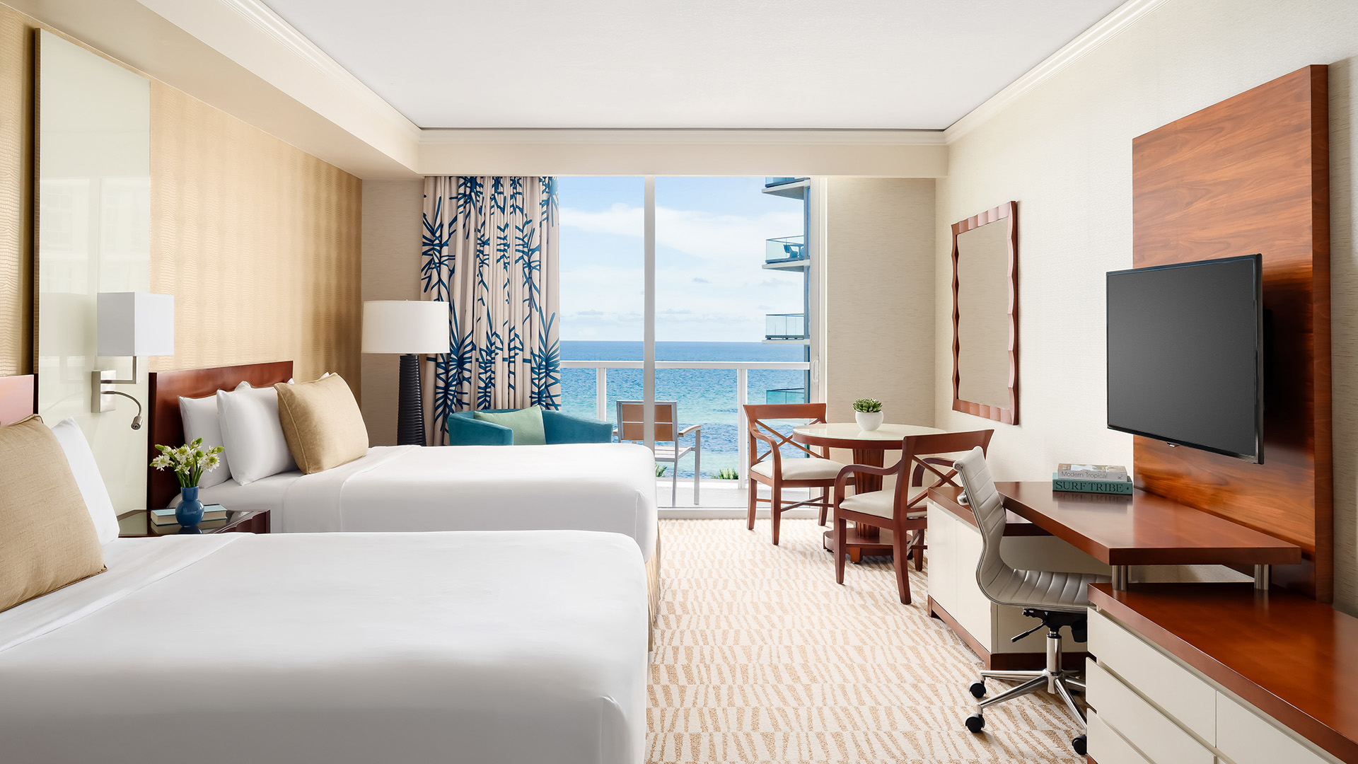 a room with two beds and a table and chairs