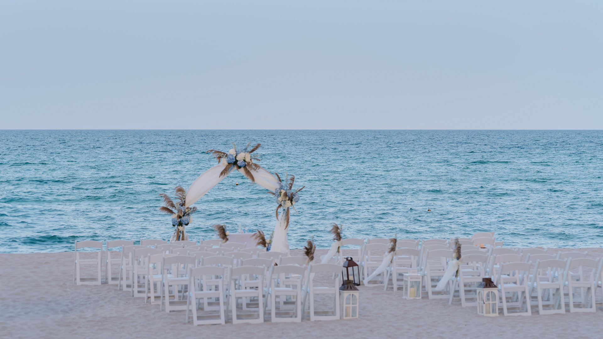 a beach wedding set up with chairs and a large body of water