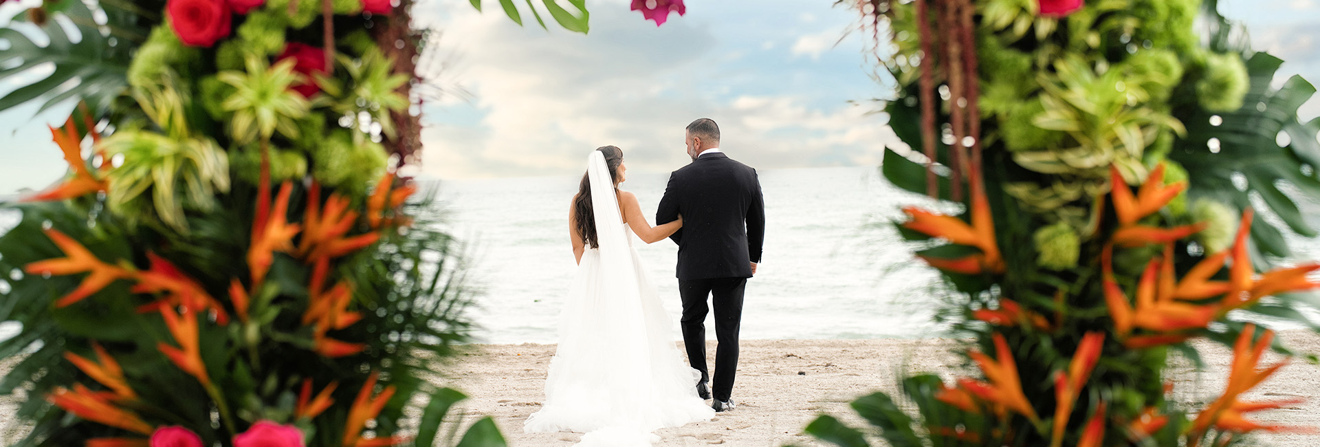 a man and woman holding hands on a beach