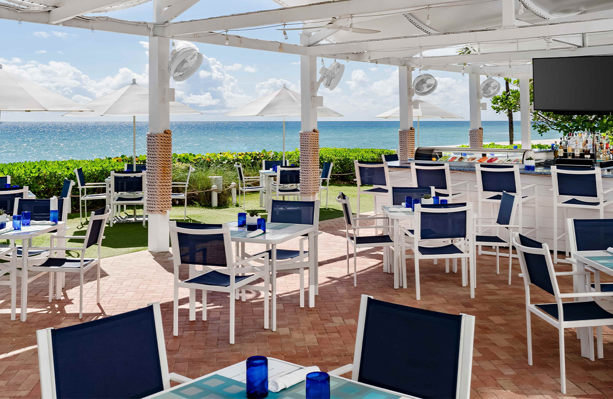 a patio with tables and chairs and umbrellas