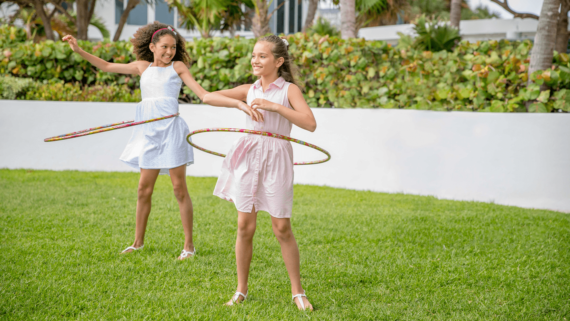 two girls holding hula hoops in a yard