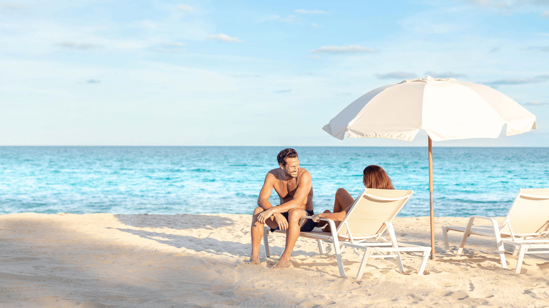 a man and woman sitting on a beach chair