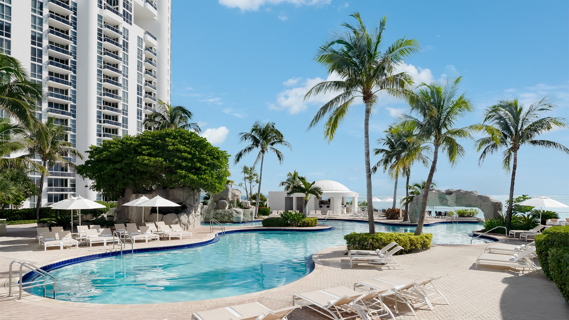 a pool with lounge chairs and palm trees