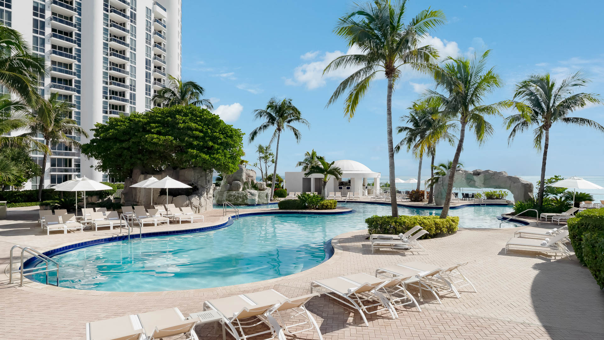 a pool with lounge chairs and palm trees