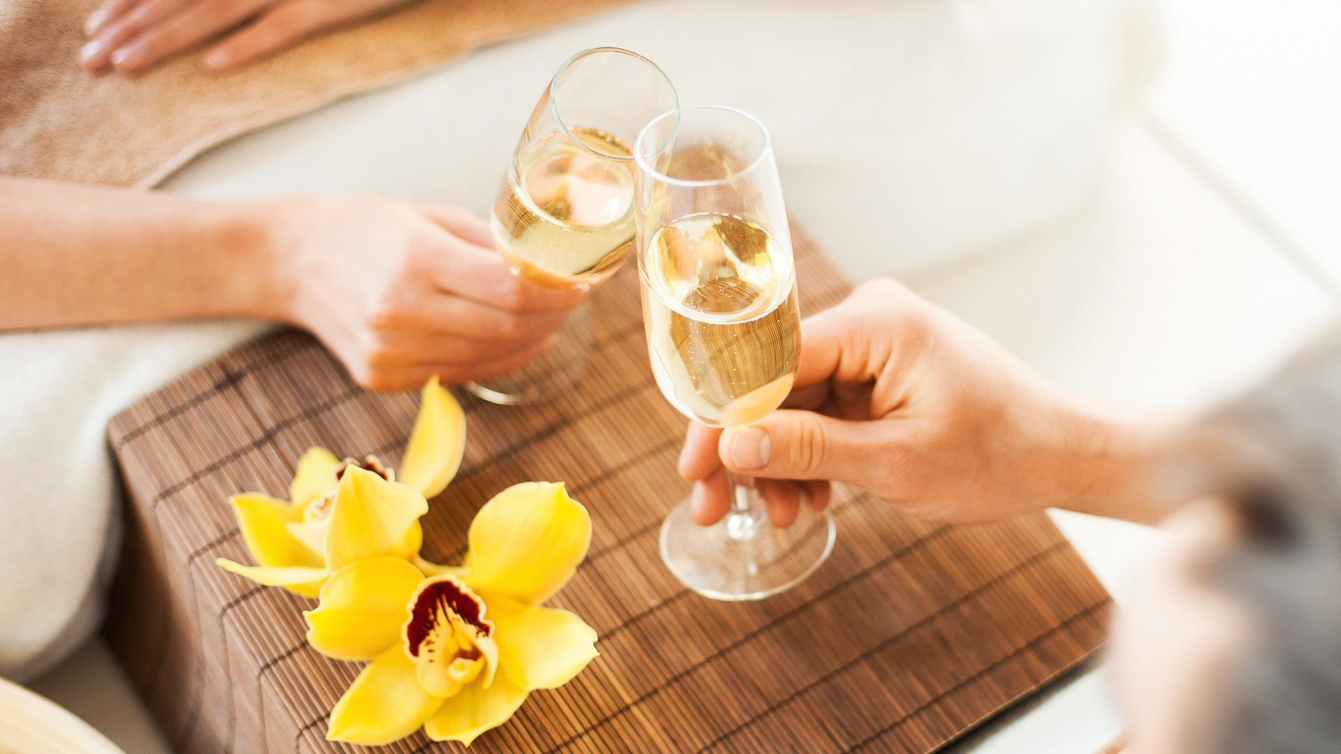 a pair of hands holding champagne glasses